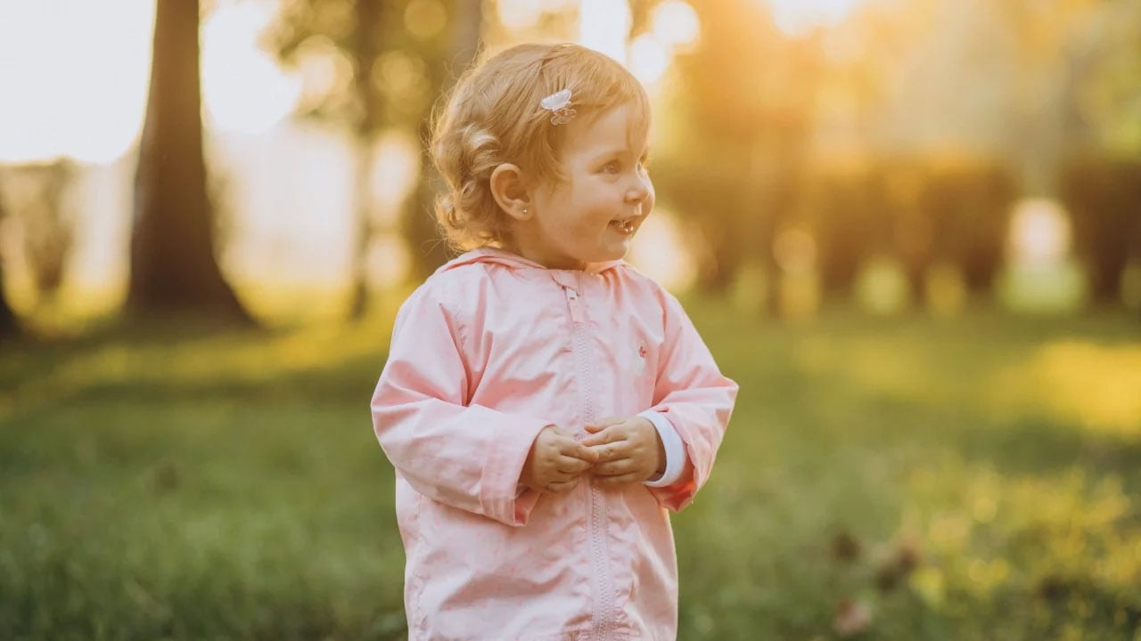 toddler in a pink raincoat