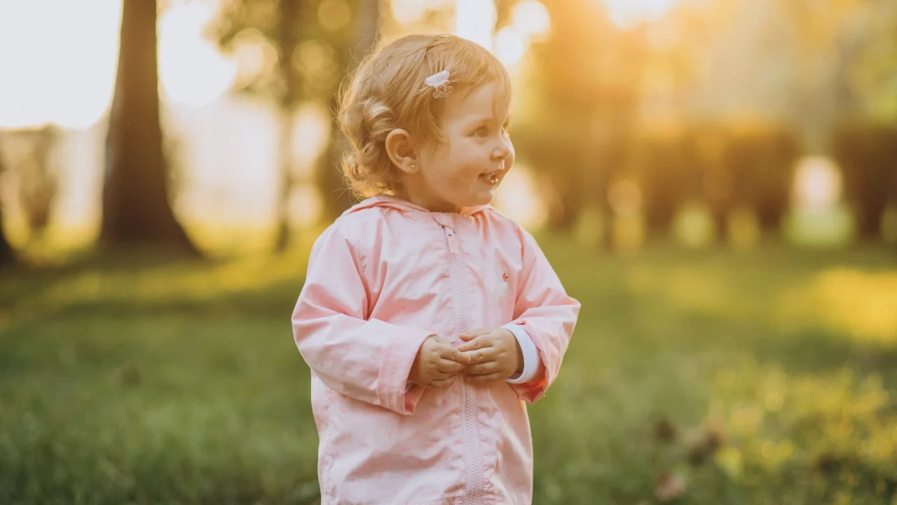 toddler in a pink raincoat